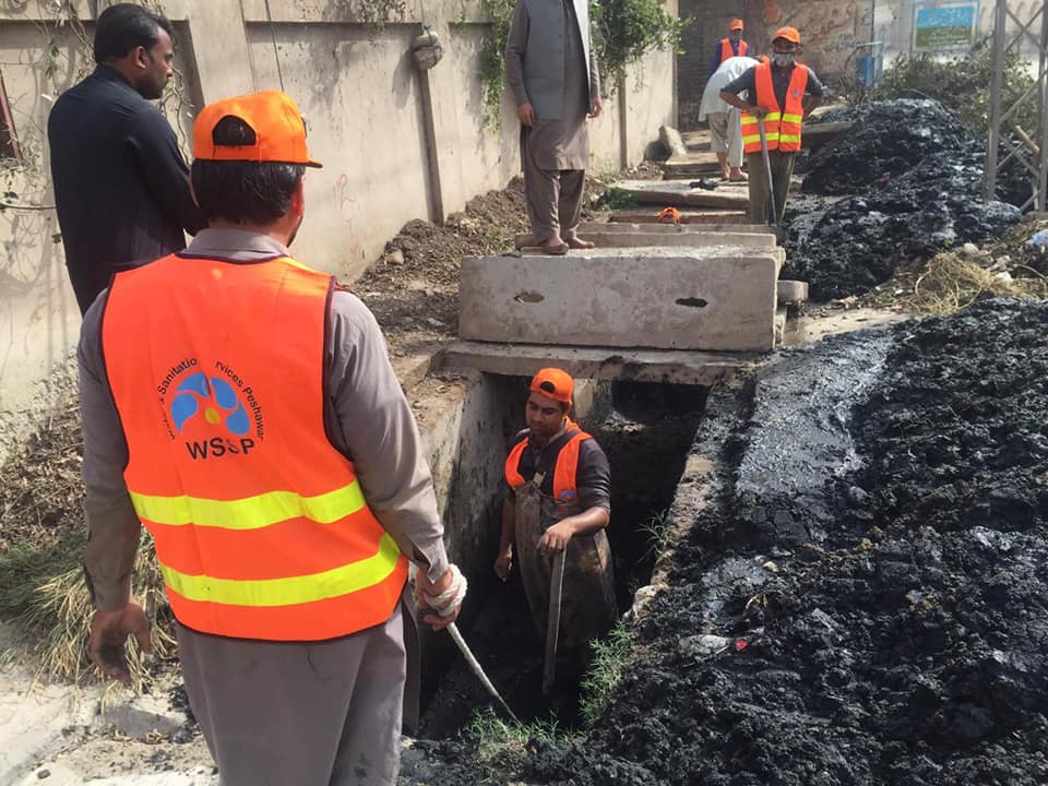 Workers cleaning drainage
